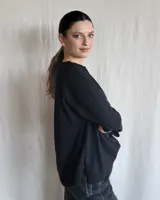 Remera de manga larga confeccionada en lanilla gris melange, con diseño holgado y escote redondo fruncido.