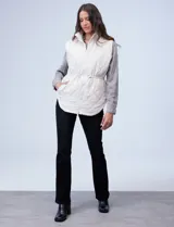 Chaleco negro capitoneado con cuello alto, cierre metálico central, bolsillos inclinados con cierre y cintura ajustable con jareta.