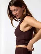 Remera sin mangas de corte crop y diseño ajustado, confeccionada en tejido rib con baño de Aloe Vera. Cuenta con top integrado, cuello redondo y detalle de logo bordado en el pecho.