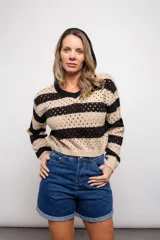 Buzo de tejido de punto calado color beige con rayas horizontales rojas y capucha.