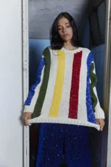 Sweater tejido a mano en lana merino con diseño a rayas verticales de colores sobre fondo crudo, cuello redondo y calce holgado.