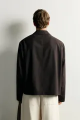 Sobrecamisa de corte relaxed fit confeccionada en tejido con mezcla de lana. Cuenta con cuello solapa, manga larga, bolsillos de parche en pecho y cadera, y cierre frontal con botones.