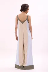 Mono palazzo color beige con terminaciones en negro, escote en V y tirantes anchos.