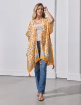 Kimono tejido color naranja con estampado abstracto en blanco y celeste, con terminación de ruedo con borlas.