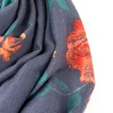 Pashmina de tela suave en color azul con estampado floral en tonos naranjas, verdes y celestes.
