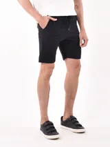 Bermuda negra con textura acanalada, corte recto y cintura con cordón ajustable.