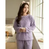 Conjunto de pijama de dos piezas confeccionado en plush suave con textura de ochos. Incluye una remera de manga larga con cuello redondo y un pantalón de corte recto con cintura elástica.