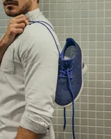 Zapatilla de diseño minimalista confeccionada en lana merino, con forro interior del mismo material y suela de EVA. Presenta cordones al tono y un diseño atemporal de estilo universal.