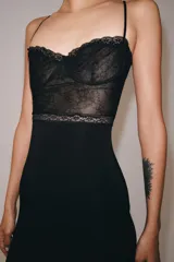 Vestido midi negro de tirantes finos, con corpiño estructurado y detalle de encaje negro en la parte superior.