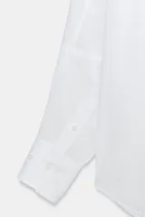 Camisa oversize de cuello solapa, manga larga con hombro caído y puños con pliegues. Presenta un bolsillo de plastrón en el frente, detalle de pinza con trabilla y botón en la espalda, bajo asimétrico y cierre frontal con botones.