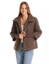 Tapado de tejido bouclé color marrón, con silueta evasé y largo a la cadera. Presenta cuello alto envolvente, cierre frontal oculto con botones a presión y bolsillos frontales de gran tamaño. Sus mangas son 3/4 con corte amplio y puños de tejido rib al tono que se extienden para cubrir las muñecas.