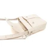 Bandolera mediana color beige, con cuerpo de textura símil cuero reptil y solapa lisa. Cuenta con correa ajustable y herrajes plateados, además de un detalle metálico con logo en la solapa.