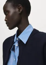 Cardigan de punto de corte recto y diseño clásico, con cuello redondo y cierre frontal mediante botones. Presenta mangas largas y un tejido de punto medio.