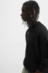 Jersey de punto de tacto suave con diseño de rayas horizontales anchas en color rosa claro y marrón oscuro. Presenta cuello redondo, manga larga y terminaciones en rib.