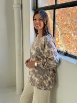 Sweater de punto con estampado animal print en tonos camel, gris y beige, de corte holgado, cuello redondo y mangas largas.