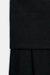 Jersey de punto liso color negro, con escote recto tipo off-shoulder con vuelta y manga larga.