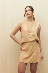 Short de lino y viscosa en color negro, con diseño de cruce delantero tipo pollera y detalle de botón lateral.