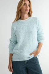Buzo de tejido de punto con textura suave, color celeste pastel con efecto jaspeado. Presenta cuello redondo, mangas largas con terminación en puño y un diseño de canalé en la parte superior del pecho.
