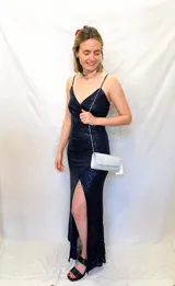 Vestido largo de fiesta azul marino con lentejuelas, escote en V y breteles finos. Presenta tajo lateral alto.