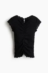 Top de algodón negro, con manga japonesa, escote en V delantero y trasero, corte ajustado y detalles fruncidos con costuras drapeadas y ribetes sobrehilados.