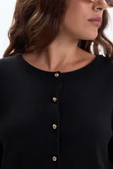 Saco de punto básico color negro, con cuello redondo y cierre frontal de botones dorados.