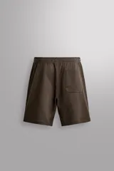 Short jogger marrón de corte relaxed fit, confeccionado en tejido compacto de algodón, con cintura elástica ajustable, bolsillos frontales en la cadera y bolsillo trasero de plastrón.