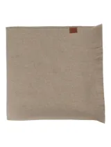 Bufanda unisex de tejido suave en color beige, con bordes desflecados y detalle de etiqueta pequeña en uno de los extremos.