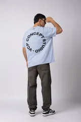 Remera verde militar de algodón con efecto lavado gastado y corte oversize. Estampa circular blanca con texto "VCP CONCEPT STUDIO" en el frente.