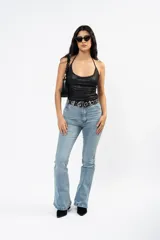 Top halter de tela metalizada negra con escote drapeado y espalda descubierta.