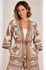 Kimono de seda liviano con estampa estilo toile de Jouy en tonos marrones y beige, con detalles de guardas geométricas, mangas tres cuartos anchas, bolsillos laterales y lazo para ajustar en la cintura.