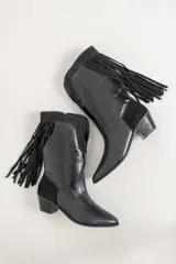 Botas de cuero color marrón con caña media, punta fina, taco de madera y detalle de flecos laterales.