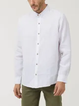 Camisa blanca de lino orgánico con cuello mao, manga larga y cierre frontal con botones de madera.