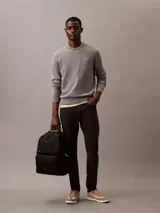 Mochila negra de poliéster reciclado con diseño minimalista. Presenta doble compartimento principal con cremallera, doble bolsillo exterior frontal con cremallera y parche con el logo de Calvin Klein.