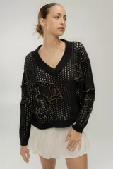 Sweater calado negro con escote en V y bordados dorados con motivos marinos.
