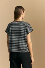 Remera de corte holgado con diseño de rayas horizontales finas en blanco y negro, cuello redondo y mangas cortas con dobladillo.