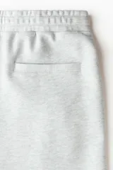Pantalón tipo jogger de punto de peso medio con pliegue frontal cosido, cintura elástica con cordón de ajuste, bolsillos laterales y bolsillo trasero insertado.