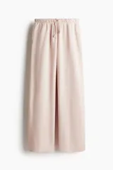 Pantalón jogger de felpa color rosa pálido, con cintura elástica ajustable con cordón, corte holgado, bolsillos laterales y piernas amplias.