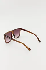 Lentes de sol negros con marco cuadrado y lentes grises. Diseño moderno y minimalista.