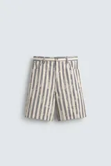 Bermuda de hombre color beige con estampado de rayas verticales azules con efecto desgastado. Corte relaxed fit, con cierre frontal de cremallera y botón, bolsillos delanteros y bolsillos traseros de plastrón.