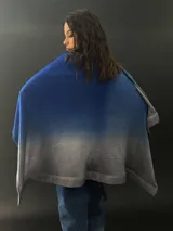 Ruana roja con degradé a negro, confeccionada en lana merino teñida artesanalmente. Presenta cuello plisado en fieltro de lana merino.