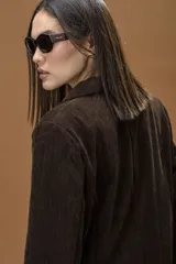 Blazer sastrero color chocolate, de corte recto y diseño relajado. Presenta solapa clásica, cierre frontal con botón y bolsillos delanteros con solapa.