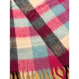 Bufanda rectangular de tejido grueso con diseño de cuadros en tonos azul, naranja, gris y beige, terminada con flecos en los extremos.