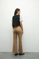 Pantalón ancho de tiro alto, color negro, con pretina y doble botón metalizado.