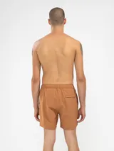 Short de baño azul marino con bordado de enredadera en la pierna izquierda. Tiene cintura elástica con cordón regulable, bolsillos laterales y trasero con cierre, y suspensor de malla fina hipoalergénico.