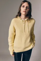 Sweater de punto suave color amarillo, con cuello redondo, hombros caídos y diseño de corte clásico.