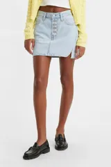Falda corta de denim color celeste claro, con cierre frontal de botones y talle medio. Presenta un diseño asimétrico con un corte en el ruedo lateral.