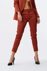 Pantalón de vestir color bordó, de corte cigarette y tiro medio, con bolsillos laterales y cierre frontal con botón.