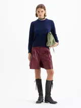 Sweater rojo de largo hasta la cadera, con mangas largas y tejido en mezcla de lana merino y algodón. De silueta holgada y cuello redondo.