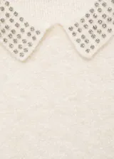 Jersey de punto de textura suave en color crudo, con cuello polo decorado con aplicaciones de strass y manga larga.