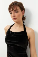 Top negro de terciopelo con escote halter, sin mangas y espalda descubierta.